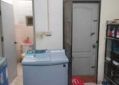 Laundry room with washing machine and storage shelf