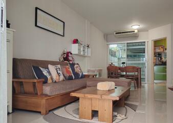 Living room with a couch, coffee table, and view into the dining area