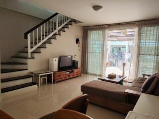 Living room with stairs and large windows