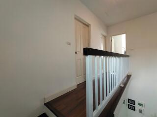 Upstairs hallway with wooden floor and white doors