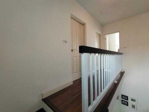 Upstairs hallway with wooden floor and white doors