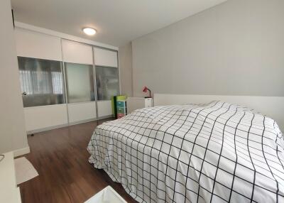 Bedroom with checkered bedding and sliding wardrobe doors