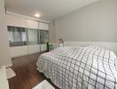 Bedroom with checkered bedding and sliding wardrobe doors