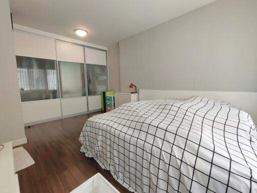 Bedroom with checkered bedding and sliding wardrobe doors