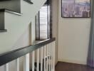 A modern staircase in a well-lit hallway with a wooden floor