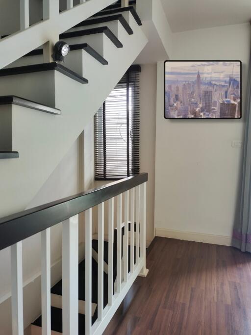 A modern staircase in a well-lit hallway with a wooden floor