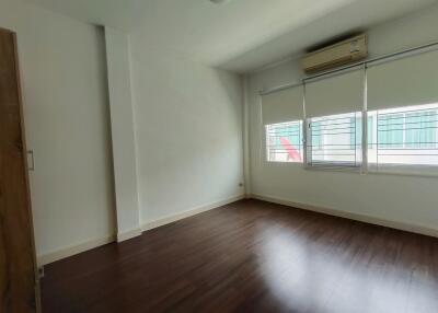 Spacious empty bedroom with wooden floor and large windows