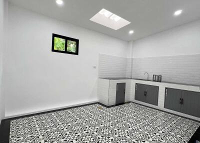 Modern kitchen with patterned tile floor and skylight