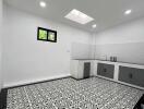 Modern kitchen with patterned tile floor and skylight