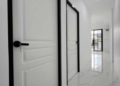 Hallway with white doors and marble floor