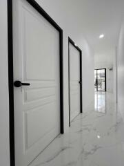 Hallway with white doors and marble floor