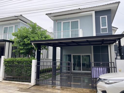 Modern two-story house with carport and small front yard