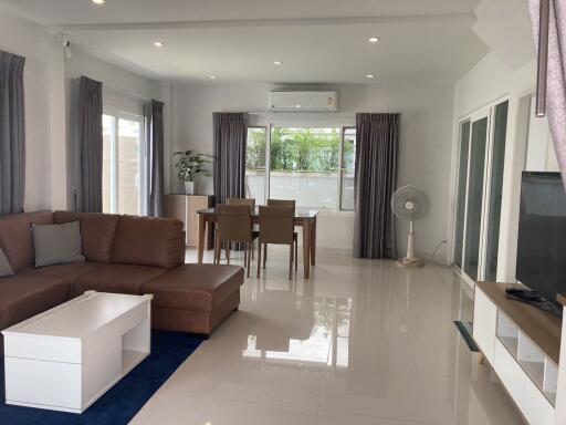 Modern living room with brown sectional sofa and dining area