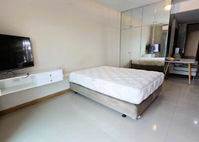 modern bedroom with mirrored closet and mounted TV