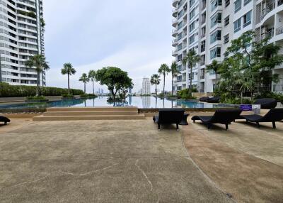 Outdoor pool area with loungers and high-rise buildings