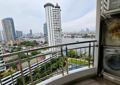 City view from balcony with river and high-rise buildings