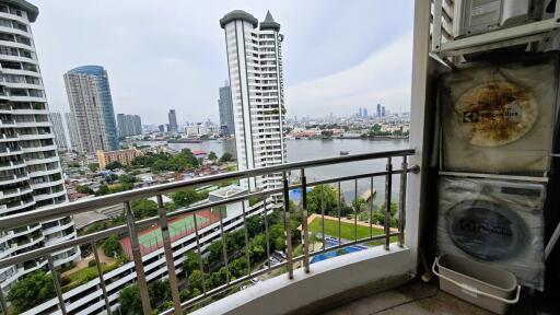 City view from balcony with river and high-rise buildings