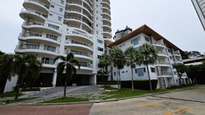 Exterior view of residential buildings with palm trees and parking area