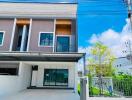 A two-story modern townhouse with a small front yard