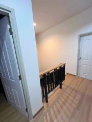 Hallway with wooden flooring and painted doors