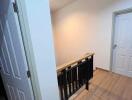 Hallway with wooden flooring and painted doors