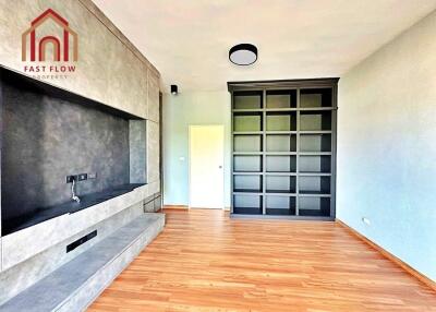 Modern living room with wooden flooring and built-in shelving.