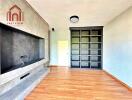 Modern living room with wooden flooring and built-in shelving.