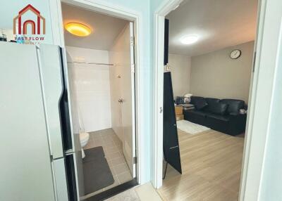 Entry view showing bathroom, living area, and part of the kitchen