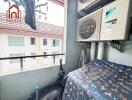 Small balcony with air conditioning units and laundry hanging