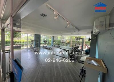 Modern fitness room with exercise equipment and large windows