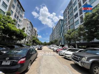 Residential apartment buildings with parking lot and cars