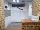 Unfurnished commercial space with brick walls and utility panel