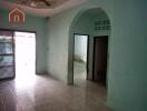 Empty room with tiled floor, archway, and doorways