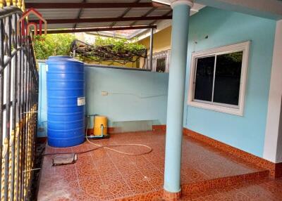 Outdoor area with water storage tank, tiled floor, and window