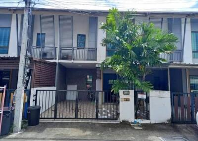 Front view of a modern townhouse with a small courtyard and gated entrance