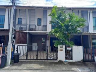 Front view of a modern townhouse with a small courtyard and gated entrance