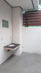 Utility area with sink and tiled walls