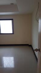 Simple empty bedroom with a window and tiled floor