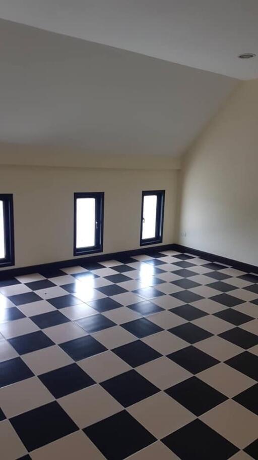 Room with checkered floor tiles and windows