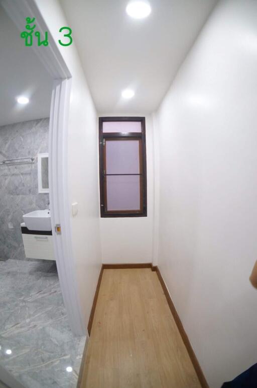 Narrow corridor leading to a bathroom