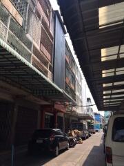 Street view of a row of buildings with parked cars