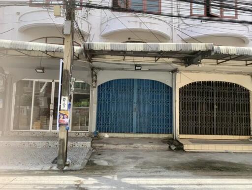 Exterior view of a building with blue and black shutters with a small driveway