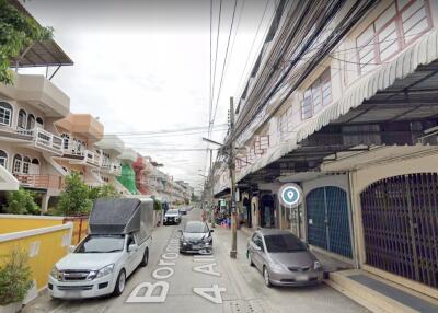 Street view of residential area with cars parked alongside the road