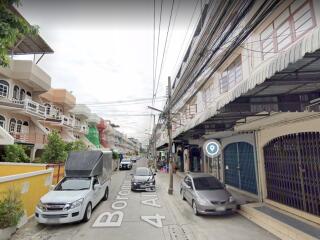 Street view of residential area with cars parked alongside the road