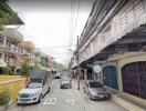 Street view of residential area with cars parked alongside the road