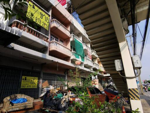 Street view of residential and commercial buildings with various signs