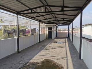 Spacious outdoor balcony with covered roof and protective fencing