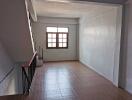 Empty bedroom with window and staircase