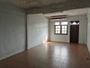 spacious, empty living room with tiled flooring and large window