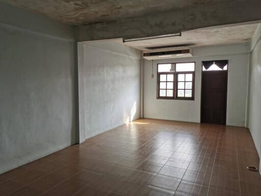 spacious, empty living room with tiled flooring and large window